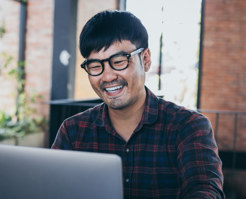 Smiling Man Using Computer In Office