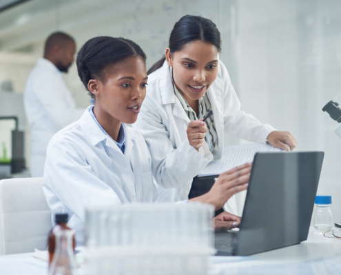 Shot Of Two Young Scientists Using A Laptop In A Laboratory