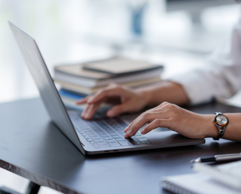 Close Up Of A Business Woman Typing A Laptop Computer On A Desk In The Office