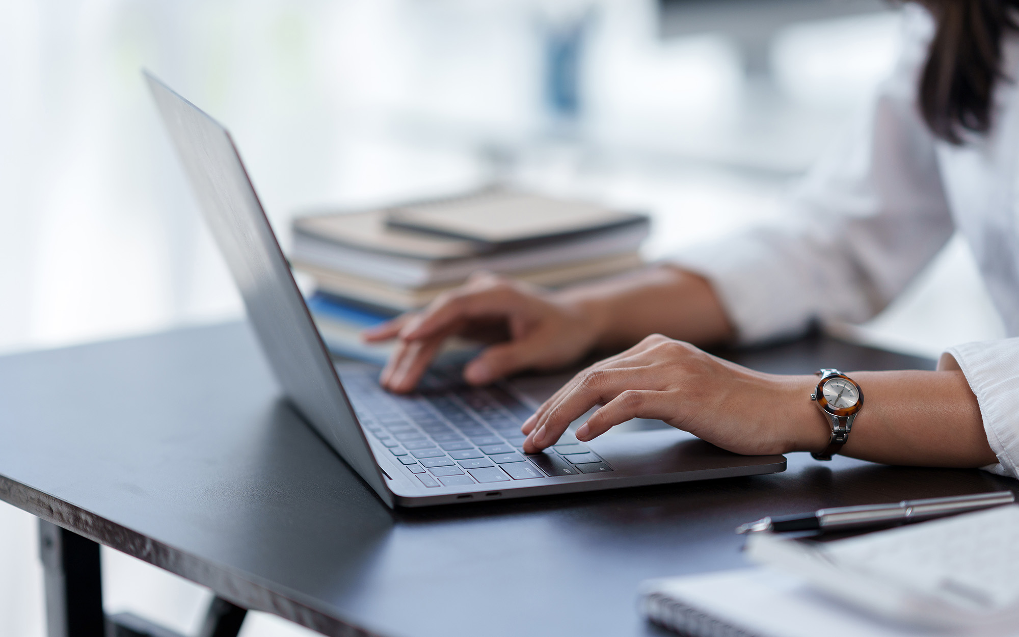 Close Up Of A Business Woman Typing A Laptop Computer On A Desk In The Office