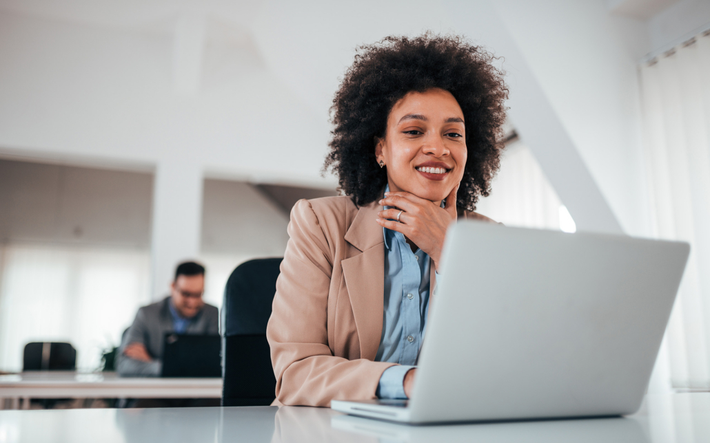 Cheerful Brunette Lady In Bright Office Working On Laptop