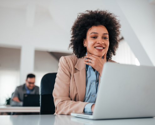 Cheerful Brunette Lady In Bright Office Working On Laptop